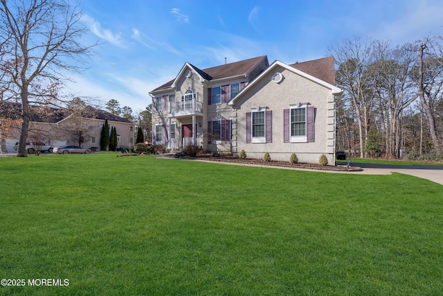 view of front of home featuring a balcony and a front lawn