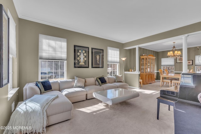 living area featuring carpet floors, decorative columns, a chandelier, and ornamental molding