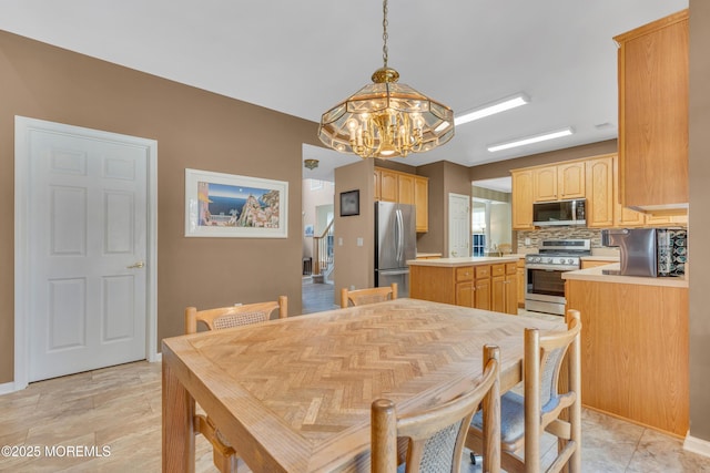 dining room with a notable chandelier and baseboards