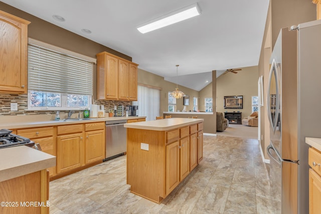 kitchen with a sink, light countertops, appliances with stainless steel finishes, and a kitchen island