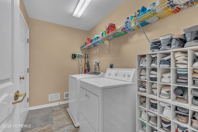 washroom featuring laundry area, independent washer and dryer, visible vents, and baseboards