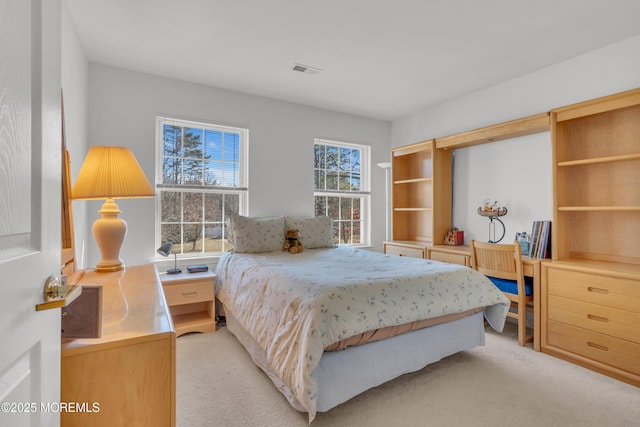 bedroom featuring visible vents and light colored carpet