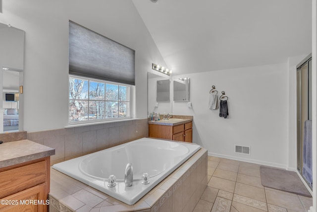 full bath featuring a garden tub, lofted ceiling, visible vents, vanity, and tile patterned flooring