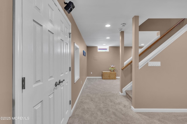 interior space featuring recessed lighting, light carpet, baseboards, and stairs