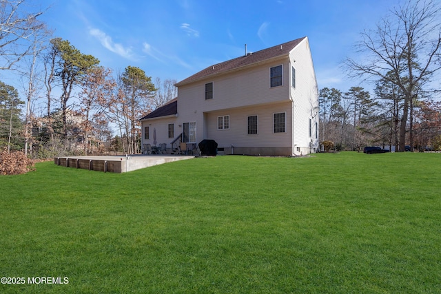 rear view of property featuring a patio and a yard