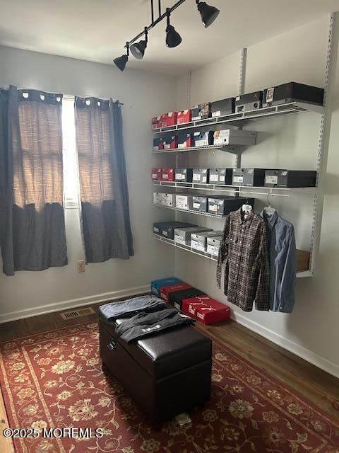 living area featuring visible vents, wood finished floors, and baseboards