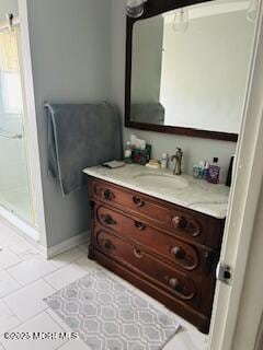 full bathroom with tile patterned floors, baseboards, a shower stall, and vanity