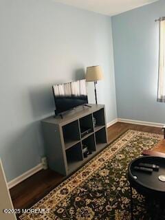 interior space featuring baseboards and dark wood-style flooring