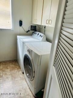 clothes washing area featuring cabinet space and independent washer and dryer