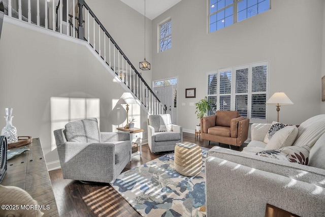 living area featuring a healthy amount of sunlight, stairway, and wood finished floors