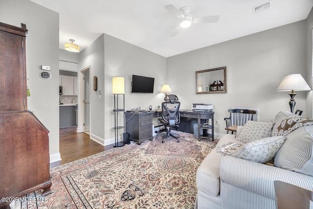 office area featuring ceiling fan, wood finished floors, visible vents, and baseboards