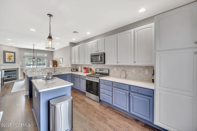 kitchen with appliances with stainless steel finishes, backsplash, visible vents, and a peninsula