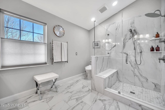 full bath with a marble finish shower, baseboards, and vaulted ceiling