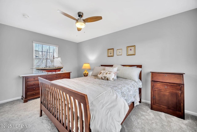 bedroom with a ceiling fan, light carpet, and baseboards