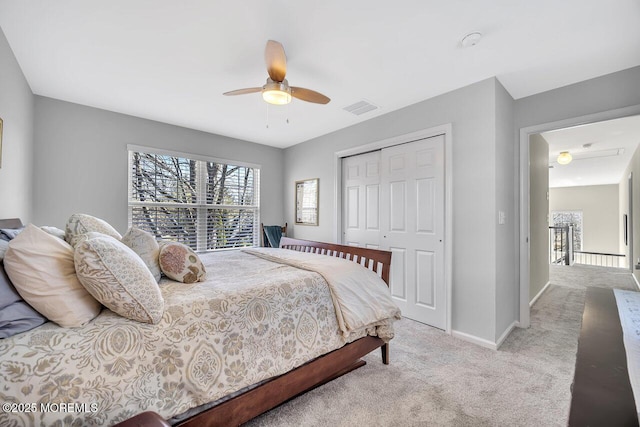 bedroom featuring a closet, light colored carpet, visible vents, and multiple windows