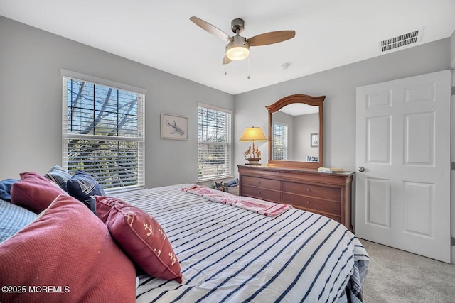 bedroom featuring light carpet, ceiling fan, and visible vents