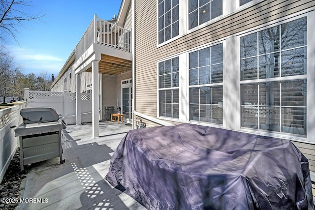 view of patio featuring a grill, a balcony, and fence