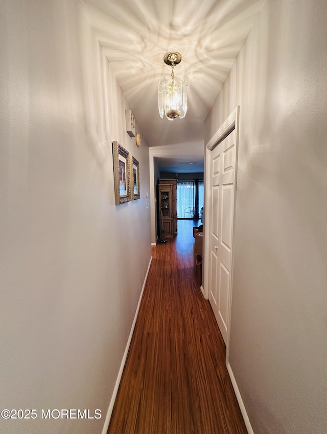 corridor featuring dark wood-style floors and baseboards