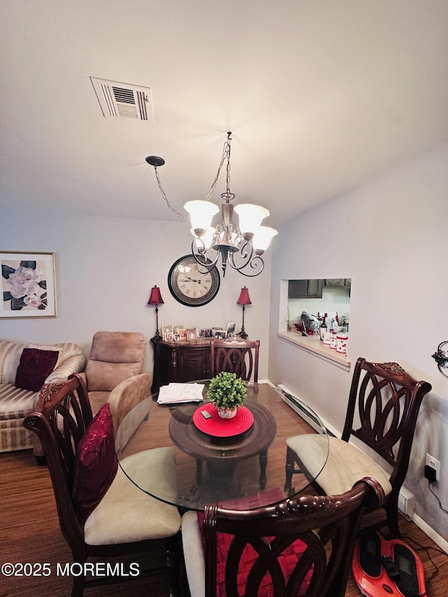 dining space featuring a notable chandelier, wood finished floors, visible vents, baseboards, and baseboard heating