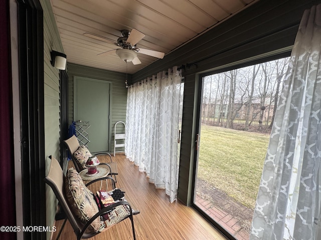 sunroom with wood ceiling and a ceiling fan