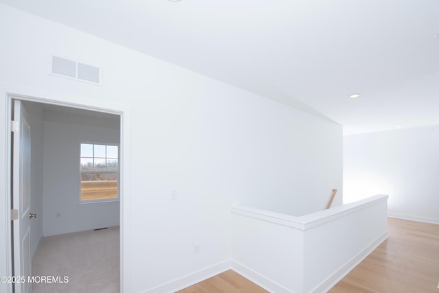 hall with recessed lighting, visible vents, light wood-style floors, an upstairs landing, and baseboards