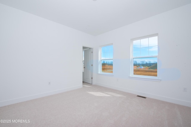 unfurnished room with light carpet, baseboards, and visible vents