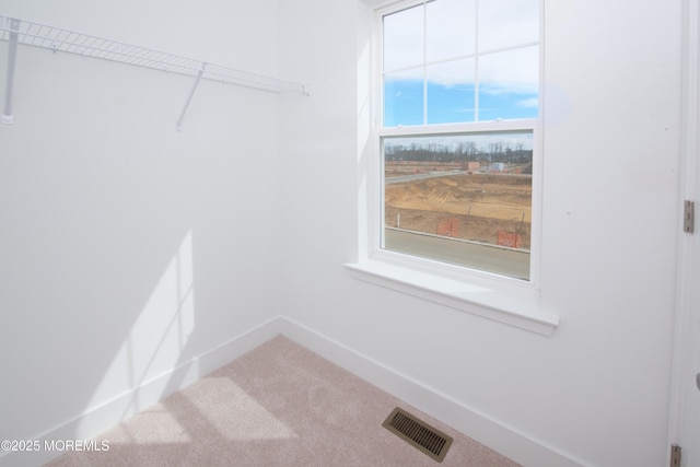 laundry room featuring carpet floors, visible vents, and baseboards