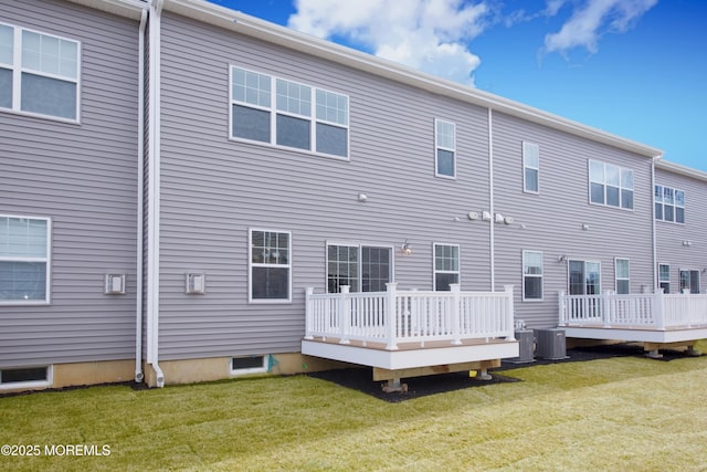 rear view of house with a yard, cooling unit, and a wooden deck