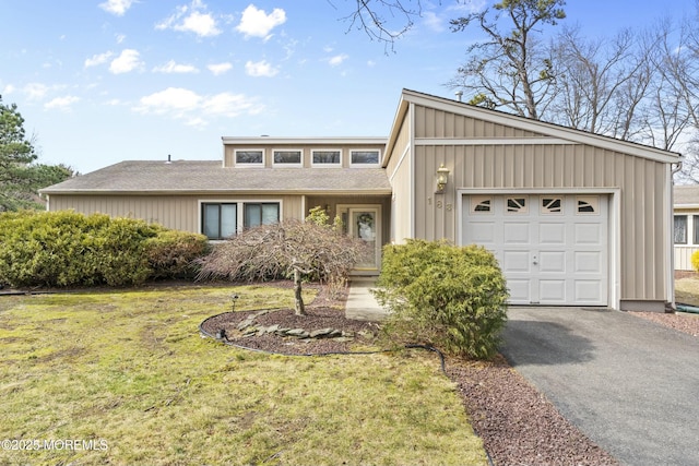 mid-century inspired home featuring an attached garage, aphalt driveway, board and batten siding, and a front yard