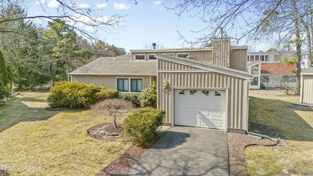 mid-century modern home with driveway, a front lawn, board and batten siding, and an attached garage