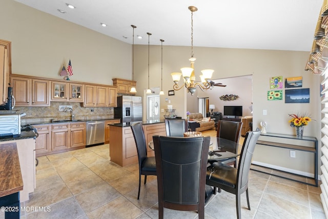 dining space with a chandelier, high vaulted ceiling, and baseboards