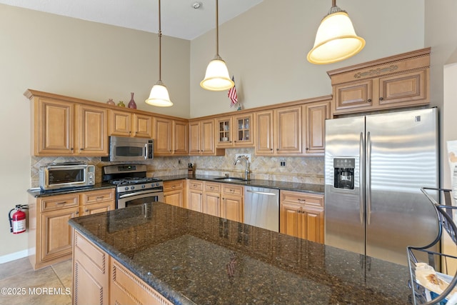 kitchen featuring a toaster, tasteful backsplash, stainless steel appliances, high vaulted ceiling, and a sink