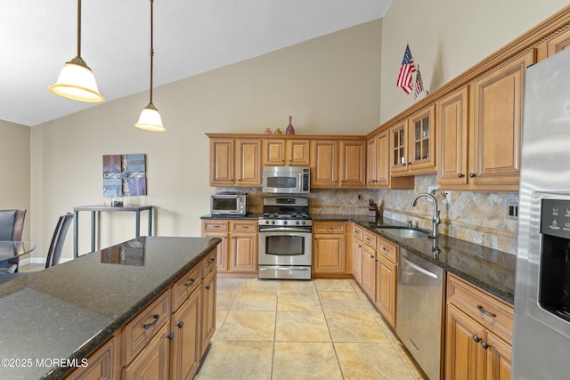 kitchen with stainless steel appliances, brown cabinetry, a sink, and tasteful backsplash