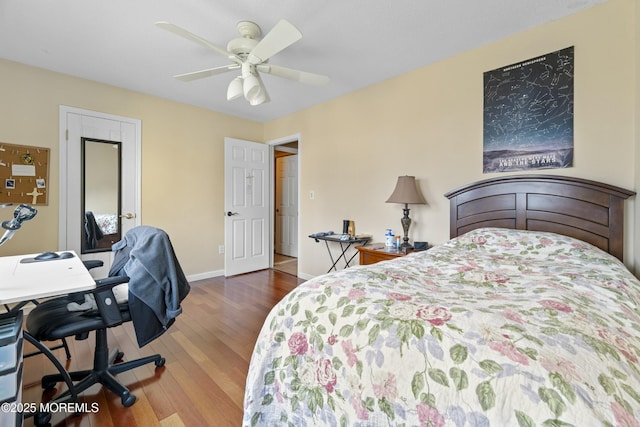 bedroom featuring a ceiling fan, baseboards, and wood finished floors