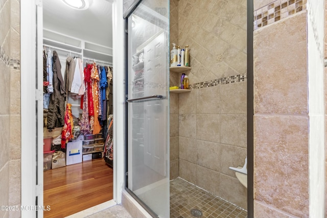 bathroom featuring a shower stall and a spacious closet