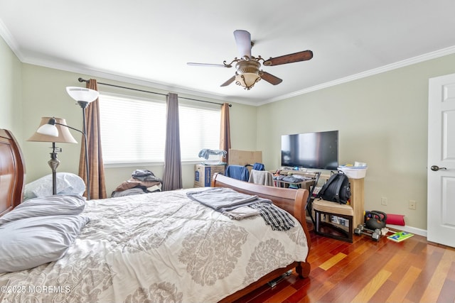 bedroom featuring ceiling fan, crown molding, baseboards, and wood finished floors