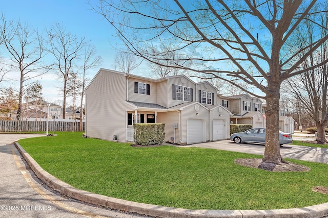 view of front of property featuring a front yard, concrete driveway, fence, and a residential view