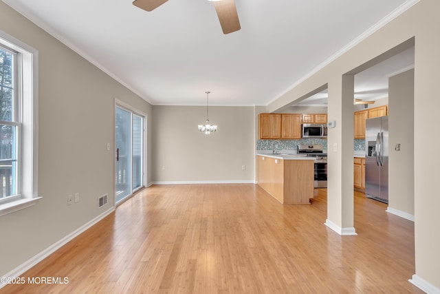 kitchen featuring crown molding, stainless steel appliances, light countertops, decorative backsplash, and light wood-type flooring