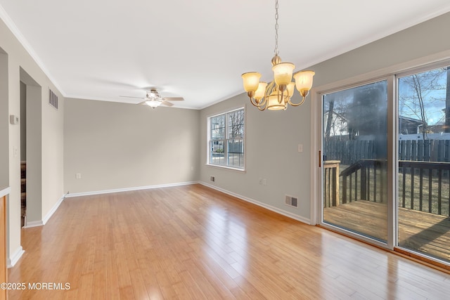 empty room with ornamental molding, light wood finished floors, and visible vents