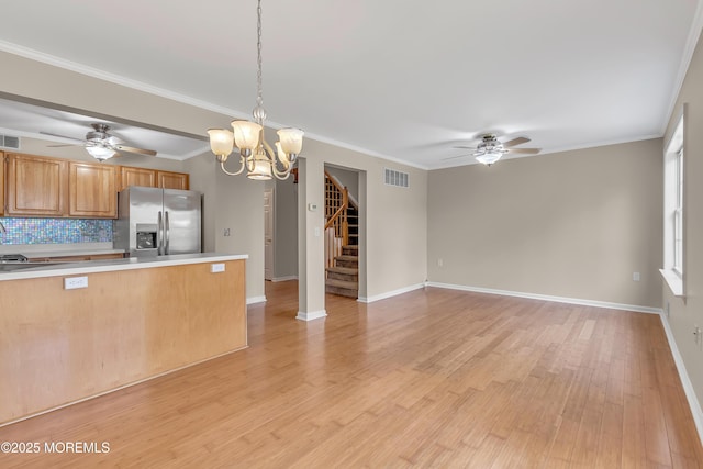 kitchen with light wood finished floors, tasteful backsplash, visible vents, stainless steel fridge with ice dispenser, and light countertops