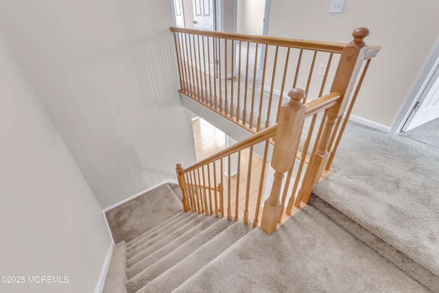 stairway featuring carpet and baseboards