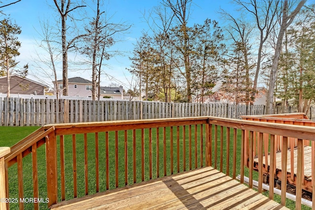 wooden terrace with a fenced backyard and a lawn