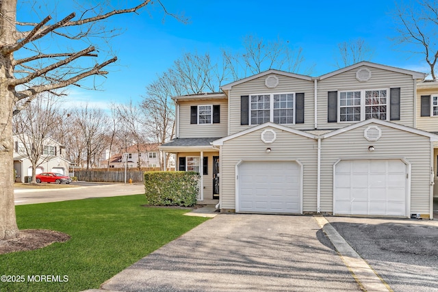 view of front of home featuring an attached garage, aphalt driveway, a front yard, and fence