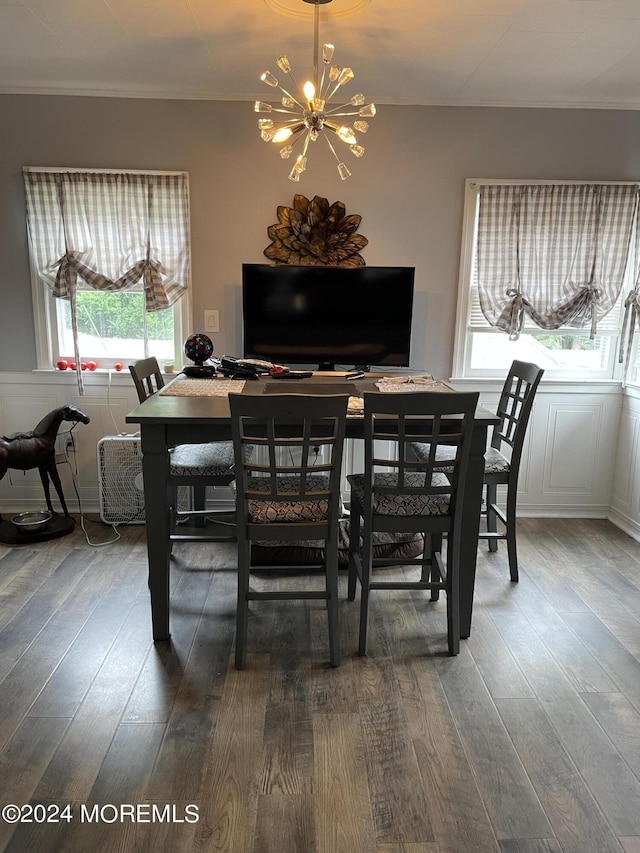 dining space featuring crown molding, wood finished floors, and a notable chandelier