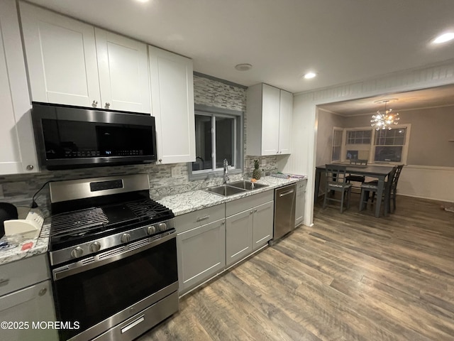 123 Harbor Inn Rd, Bayville, NJ 08721 - kitchen featuring stainless steel appliances, a sink, backsplash, a chandelier, and wood finished floors