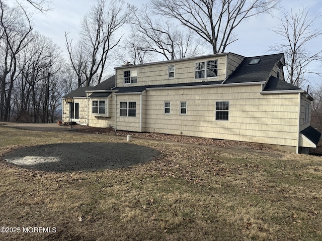 rear view of property featuring a shingled roof