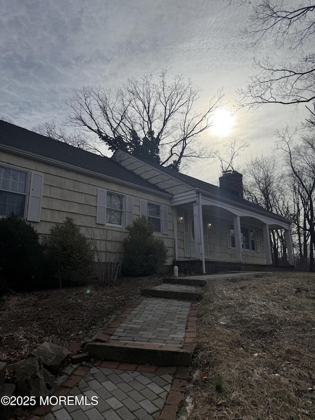 view of front of property with a chimney and a porch