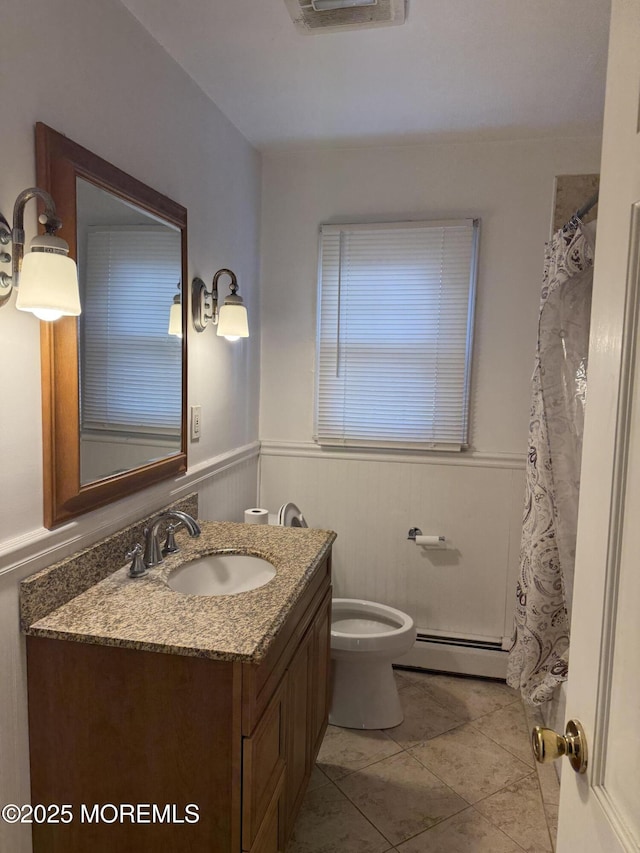 full bathroom featuring a wainscoted wall, baseboard heating, vanity, and toilet