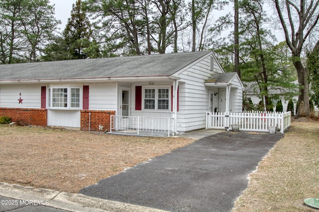 ranch-style house with brick siding, fence, and roof with shingles