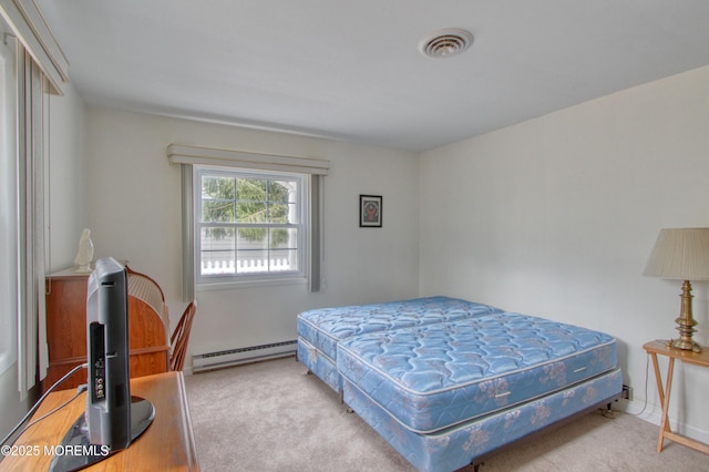 bedroom featuring a baseboard heating unit, carpet flooring, and visible vents